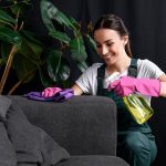 Kobieta czyszcząca tapicerkę kanapy